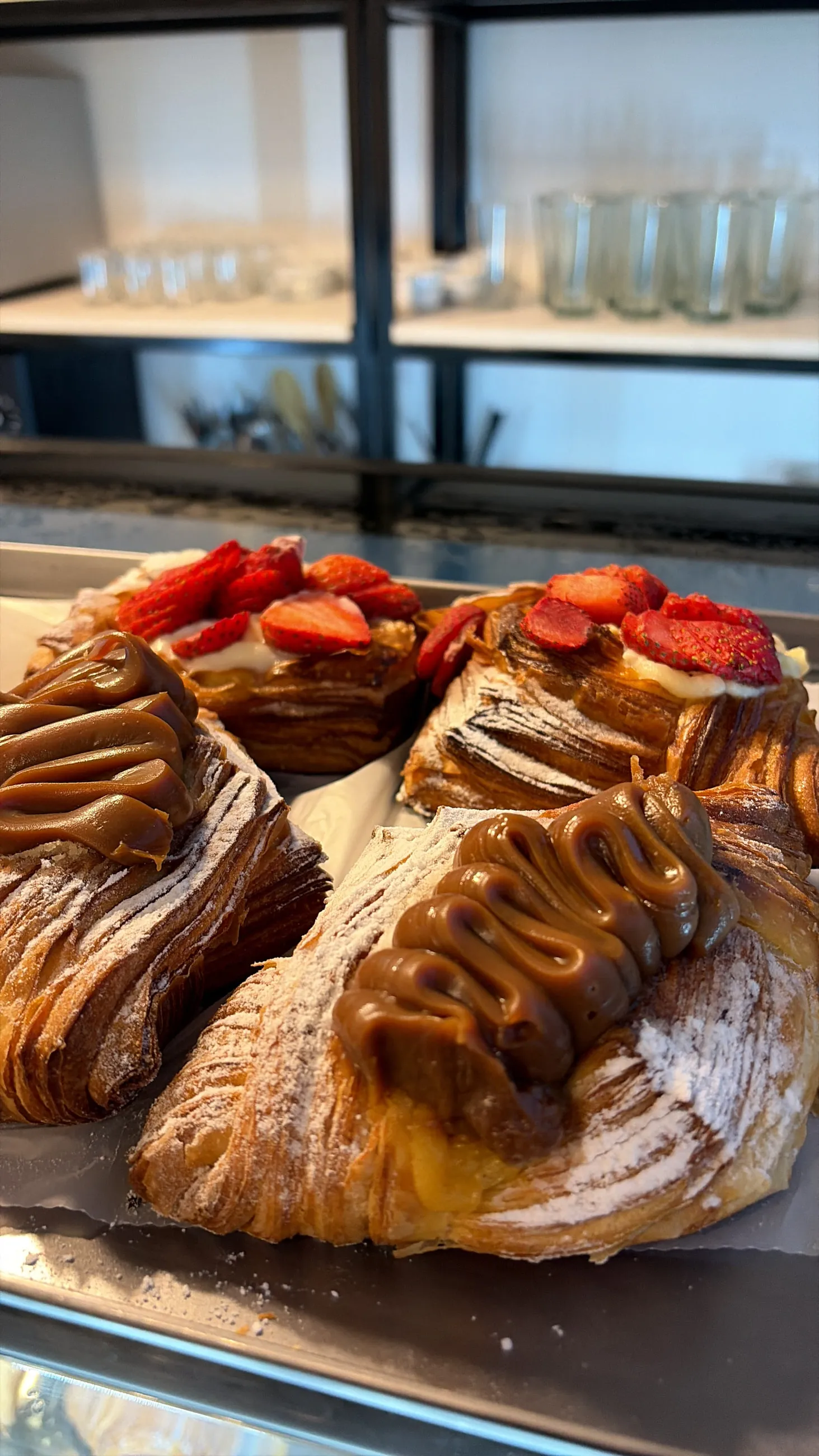 Croissants con dulce de leche y frutillas sobre una bandeja