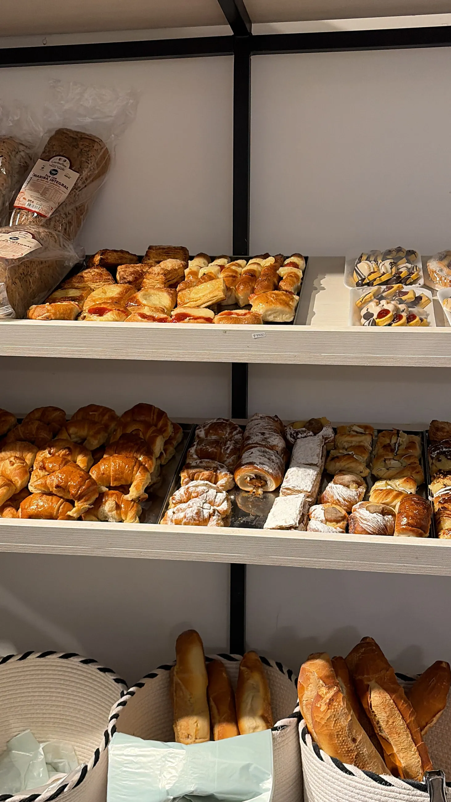 Estantes con facturas, medialunas y panes recién horneados